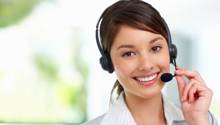 Pretty female employee speaking on headset